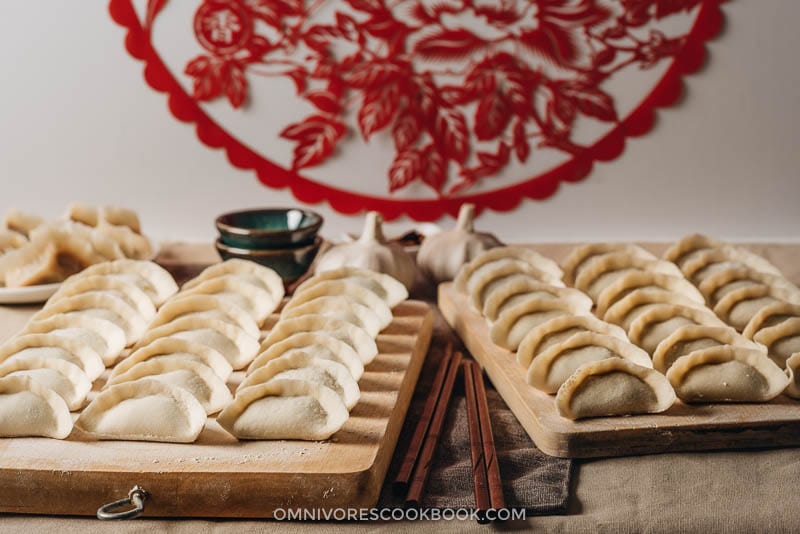 Uncooked Chinese dumplings on cutting boards