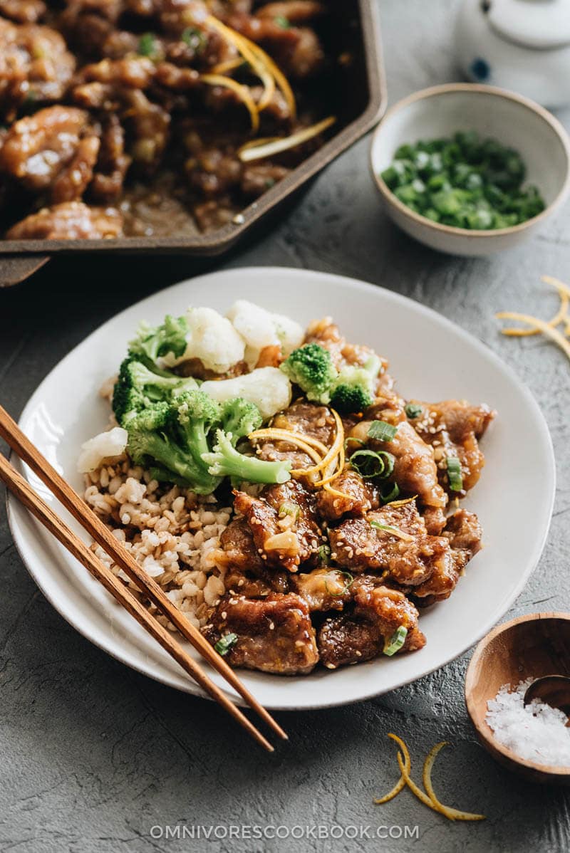 Orange beef served in a plate with rice, cauliflowers and broccoli