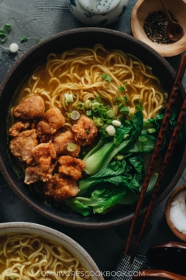 Chinese noodle soup topped with crispy chicken and baby bok choy