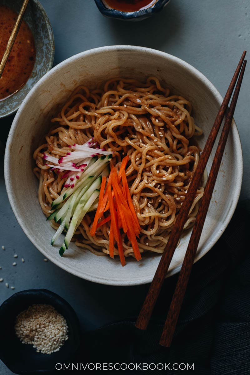 Chinese sesame noodles in a bowl with cucumber and radish