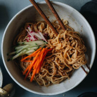 Sesame noodles is a perfect dish for a hot summer night when you don’t feel like standing in front of a hot stove. The nutty savory sauce that has a hint of sweetness and spiciness, it’s always a crowd pleaser. You can simply serve it without any toppings as a side dish. You top it with fresh summer produce and serve it as an appetizer for your grilling party. Or you can load it up with more toppings to serve it as a main.