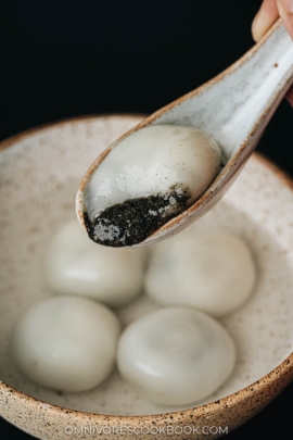 Black sesame tang yuan close up with filling oozing out