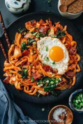Korean fried noodles with kimchi, bacon and kale
