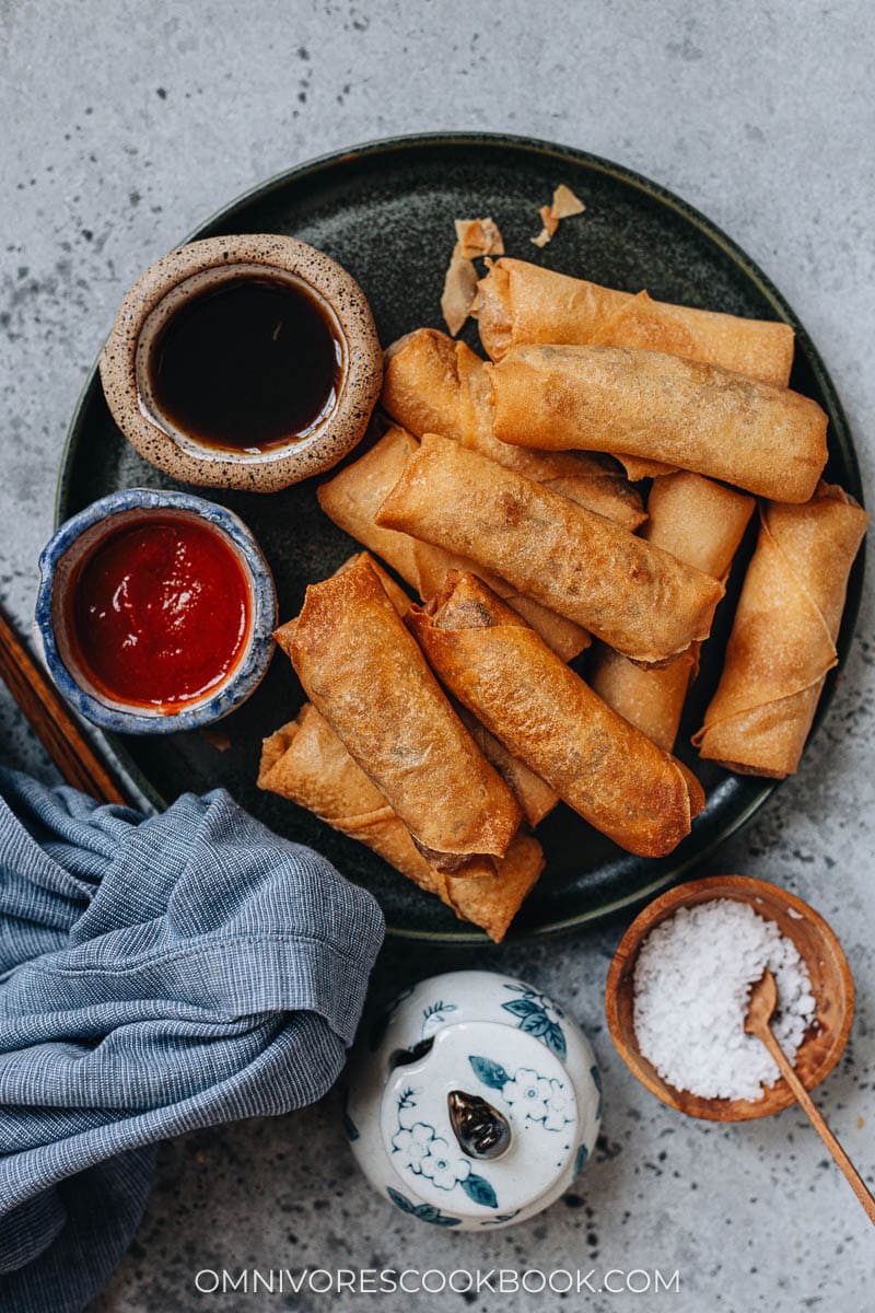 Chinese fried spring rolls on a plate with dipping sauce